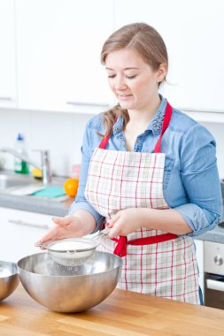 kadın onun mutfak için hafta sonu parti paslanmaz bir kase içinde bir kek malzemeleri karıştırma