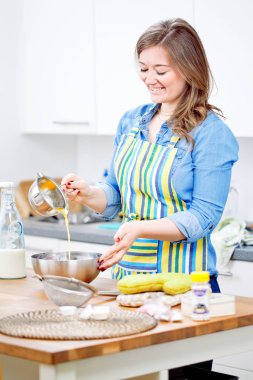 kadın onun mutfak için hafta sonu parti paslanmaz bir kase içinde bir kek malzemeleri karıştırma.