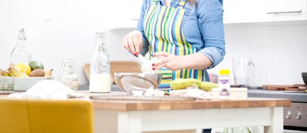 여자는 파티에 그녀의 부엌에 스테인리스 그릇에 케이크의 재료를 — 스톡 사진