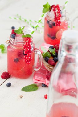 Yaz Berry içki. Limonata ile ahududu ve böğürtlen ile limon, nane beyaz masada mason kavanoza . 