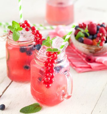 Yaz Berry içki. Limonata ile ahududu ve böğürtlen ile limon, nane beyaz masada mason kavanoza . 