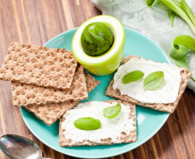 Crispbread krem peynir ve bir ahşap tahta üzerinde taze otlar ile sağlıklı kahvaltı. Sağlıklı kahvaltı.