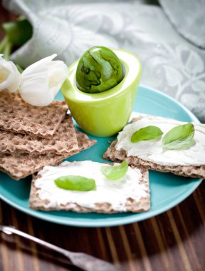 Crispbread krem peynir ve bir ahşap tahta üzerinde taze otlar ile sağlıklı kahvaltı. Sağlıklı kahvaltı.