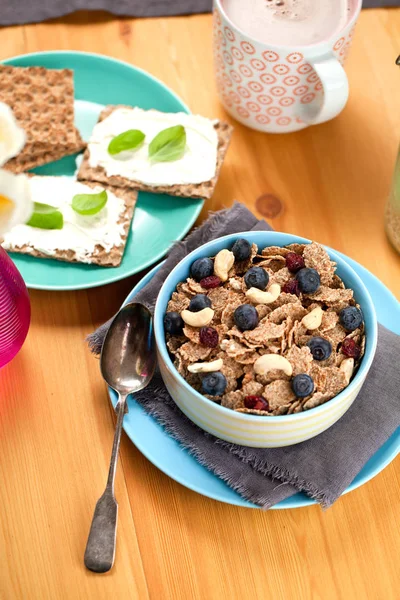 stock image Bowl of homemade granola with yogurt and fresh berries on wooden background from top view.