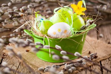 Paskalya Kukum ve Paskalya yortusu yumurta ahşap arka plan üzerinde. Mutlu paskalya kartı. Mutlu Paskalya metinle Almanca.