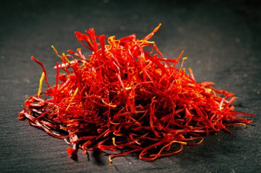 Karanlık demir döküm arka plan üzerine safran iş parçacığı yığın