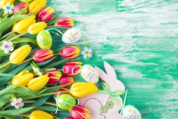 Osterhintergrund Mit Bunten Eiern Und Gelben Tulpen Über Holz Ansicht — Stockfoto