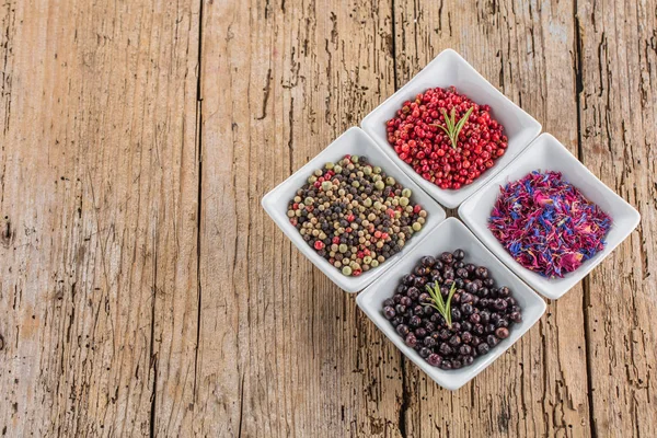 Heap of dry pink pepper on old wooden background