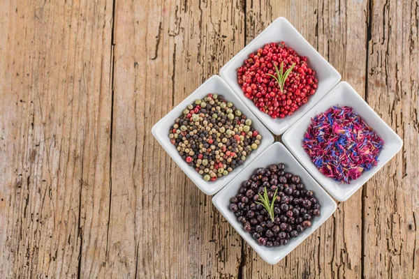 Heap of dry pink pepper on old wooden background