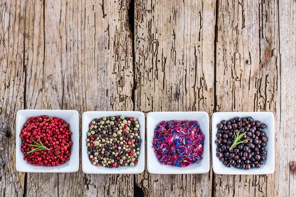 Heap of dry pink pepper on old wooden background