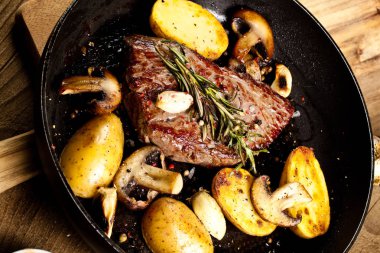 Izgara siyah Angus biftek kızartma ahşap arka plan üzerinde dökme demir ızgara tava üzerinde Striploin