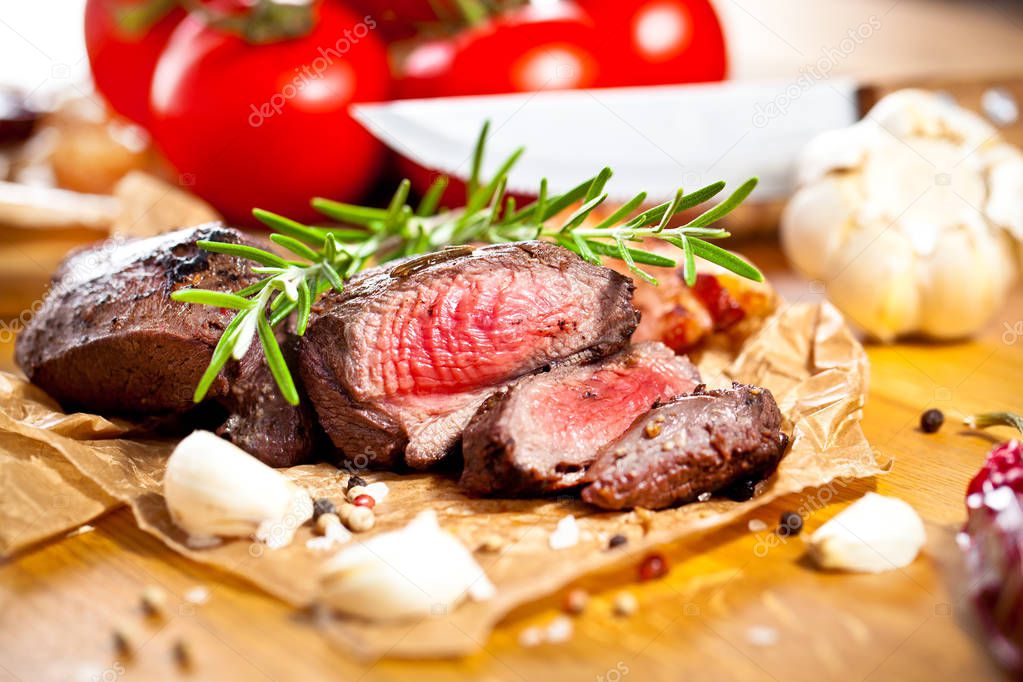 grilled venison fillet on wooden table close up