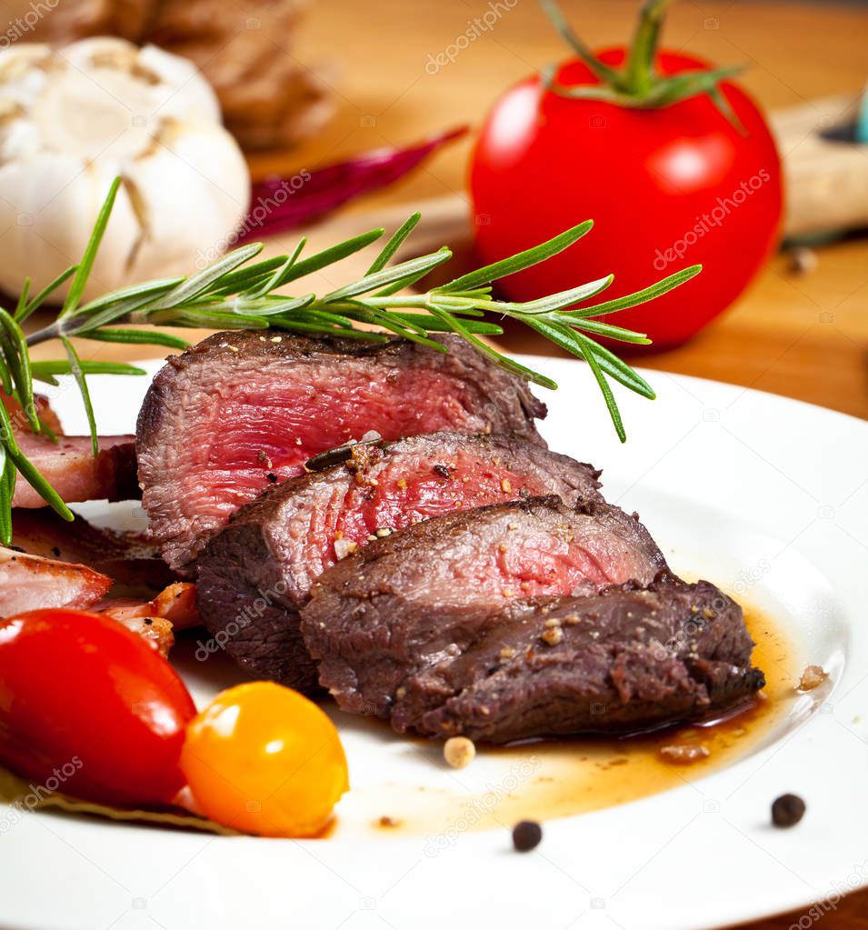 grilled venison fillet on wooden table close up