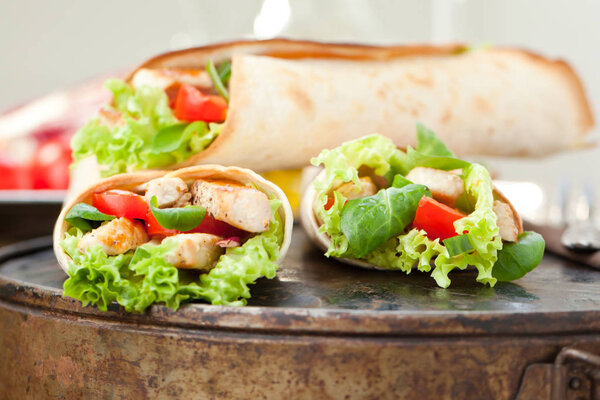 Chicken fajita wrap sandwich close up on wooden background
