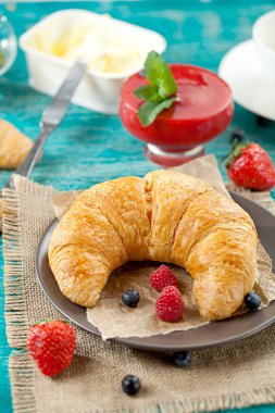 Ahududu ile eski ahşap zemin üzerine altın taze kruvasanlar yakın çekim