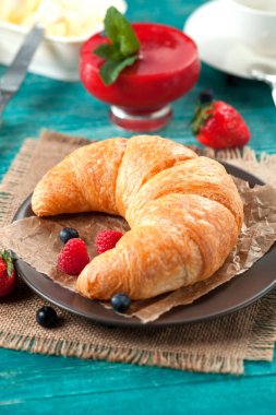 Ahududu ile eski ahşap zemin üzerine altın taze kruvasanlar yakın çekim