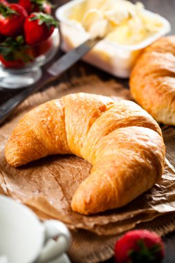 Ahududu ile eski ahşap zemin üzerine altın taze kruvasanlar yakın çekim