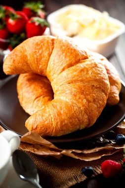 Ahududu ile eski ahşap zemin üzerine altın taze kruvasanlar yakın çekim