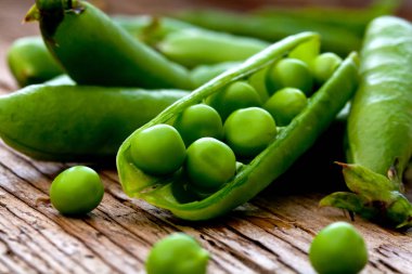 Hearthy taze yeşil bezelye ve bakla rustik ahşap zemin üzerine