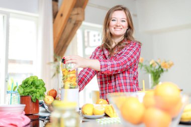 Genç gülümseyen kadın evde mutfak blender Smoothie taze yeşillikleri ile yapma.
