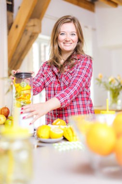 Genç gülümseyen kadın evde mutfak blender Smoothie taze yeşillikleri ile yapma.