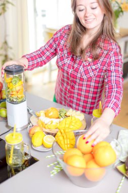 Genç gülümseyen kadın evde mutfak blender Smoothie taze yeşillikleri ile yapma.