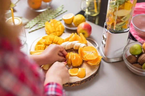 Genç gülümseyen kadın evde mutfak blender Smoothie taze yeşillikleri ile yapma.