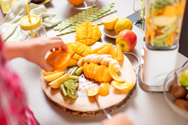 Genç gülümseyen kadın evde mutfak blender Smoothie taze yeşillikleri ile yapma.