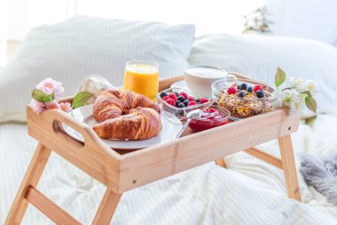 meyve ve hamur işleri bir tepsi ile yatakta kahvaltı