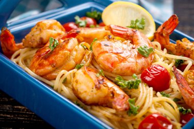 Stir-fried spaghetti with grilled shrimps and tomatoes - Italian fusion food style clipart