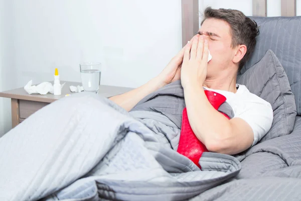 Man feeling bad lying in the bed and coughing