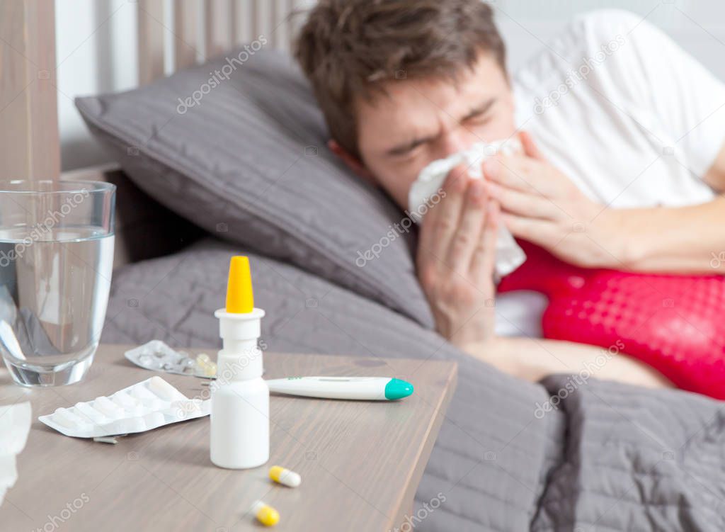 Man feeling bad lying in the bed and coughing
