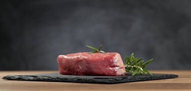 Koyu ahşap masada çiğ biftek..