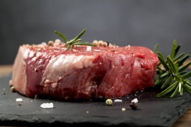 Koyu ahşap masada çiğ biftek..