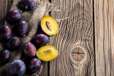 Ahşap doku arka plan üzerinde olgunlaşmış taze Erik