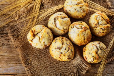 Ahşap masa üzerinde taze ekmek çeşitleri. İzole kahverengi zemin üzerine ekmek çeşitliliği