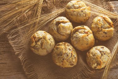 Ahşap masa üzerinde taze ekmek çeşitleri. İzole kahverengi zemin üzerine ekmek çeşitliliği