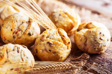 Ahşap masa üzerinde taze ekmek çeşitleri. İzole kahverengi zemin üzerine ekmek çeşitliliği