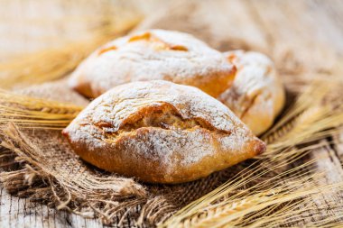 Ahşap masa üzerinde taze ekmek çeşitleri. İzole kahverengi zemin üzerine ekmek çeşitliliği.