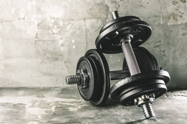 İki dumbells koyu gri yüzeyine yerleştirilen portre çekim