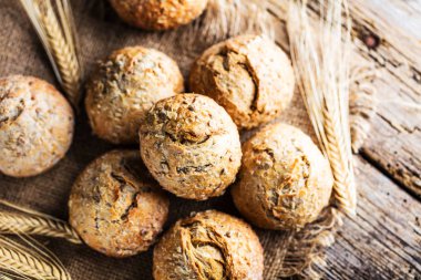 Ahşap masa üzerinde taze ekmek çeşitleri. İzole kahverengi zemin üzerine ekmek çeşitliliği