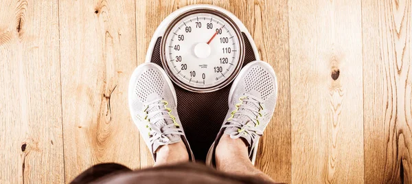 上に立っている男性のジムで体重計の重量を量る 巻尺によるウエスト測定 健康的なライフ スタイルのコンセプト — ストック写真