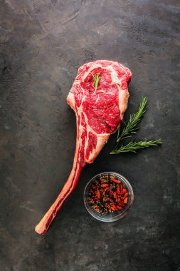 Dry aged raw tomahawk beef steak with ingredients for grilling clipart