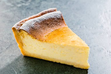 Mavi ahşap masa üzerinde lezzetli ev yapımı peynirli kek. Seçici odak