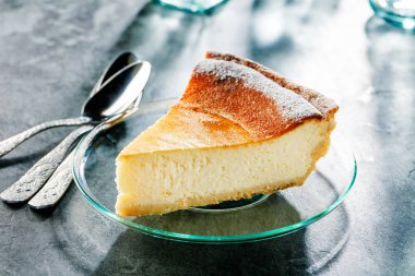 Mavi ahşap masa üzerinde lezzetli ev yapımı peynirli kek. Seçici odak