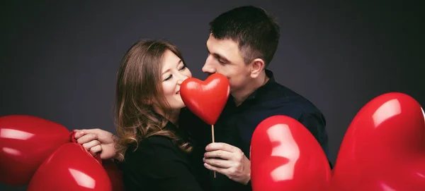 Young Couple Heart Shaped Red Balloons Grey Wall — Stock Photo, Image