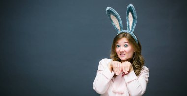 Festival sezonu bunny ve yumurta. modern kadında mutlu Easter bunny kulaklar izole gri arka plan üzerinde