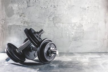 İki dumbells koyu gri yüzeyine yerleştirilen portre çekim
