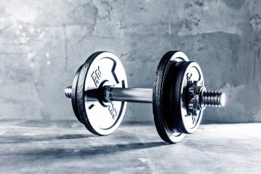 İki dumbells koyu gri yüzeyine yerleştirilen portre çekim