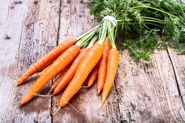 木の背景に緑の葉を持つ新鮮なニンジンの束 野菜だ 食べ物 — ストック写真